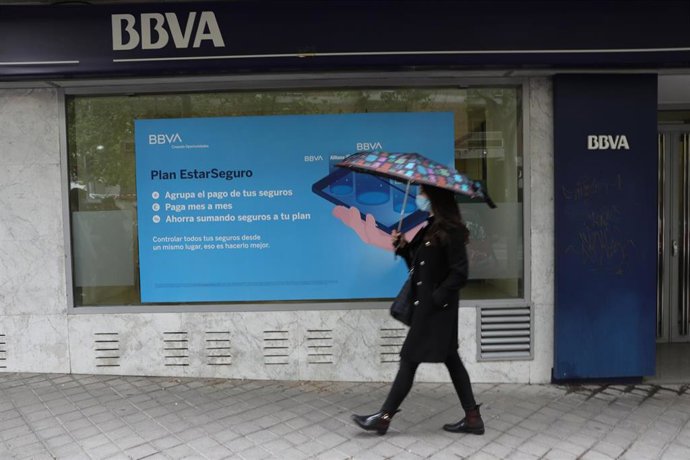 Archivo - Una persona pasa por delante de la puerta de una Oficina de BBVA en Madrid, a 22 de abril de 2021, en Madrid (España). 