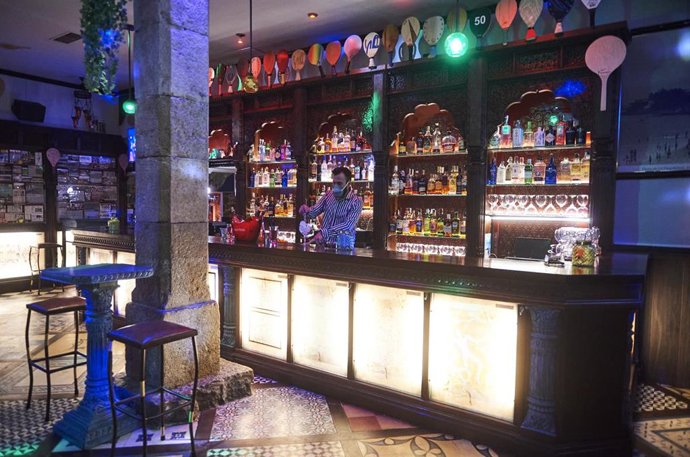 Archivo - Un trabajador prepara una copa en la barra de un bar.- Archivo