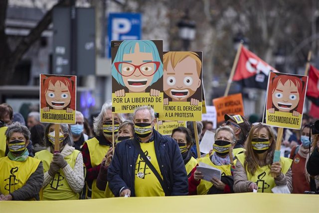 Varias personas con pancartas que rezan 'Por la libertad de información' participan en una manifestación contra la ley mordaza, a 13 de febrero de 2022, en Madrid (España).
