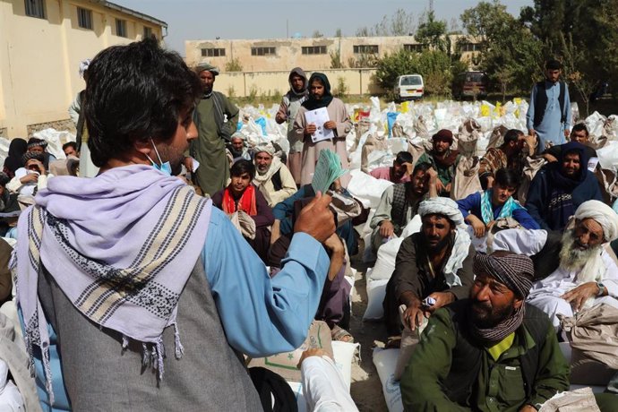 Archivo - Un voluntario entrega tickets para la entrega de raciones de alimentos en un punto de distribución del Programa Mundial de Alimentos (PMA) en Herat, Afganistán