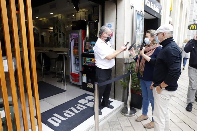 Archivo - Un camarero pide certificado a los clientes en la puerta de un bar durante el primer día de petición de Certificados Covid-19 para la hostelería, foto de archivo