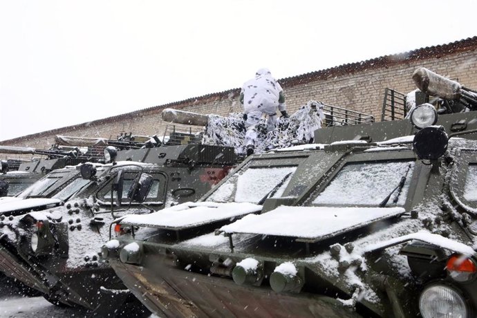 31 January 2022, Ukraine, Kharkiv: A soldier of the 92nd Mechanized Brigade of the Ukrainian Armed Forces,  wearing a white camouflage uniform, gets on a military vehicle during a military exercise in Kharkiv. Photo: -/Ukrinform/dpa