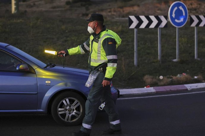 Archivo - Un agente detiene a un coche durante un control de la Guardia Civil 