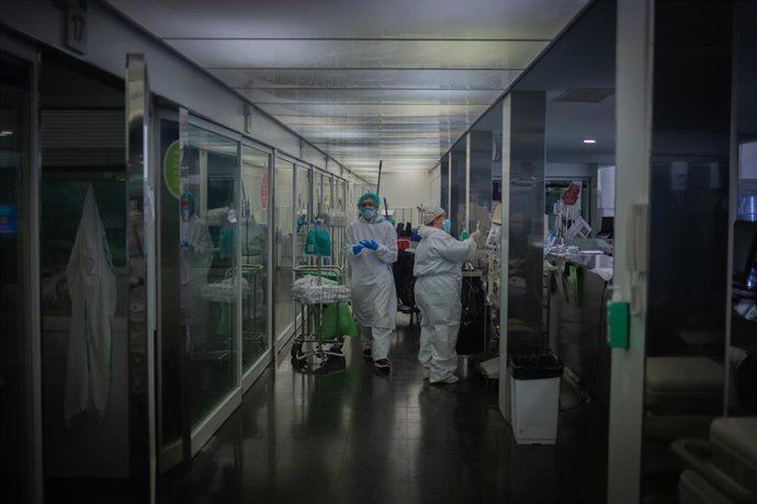 Archivo - Varios sanitarios protegidos en la Unidad de Cuidados Intensivos en una imagen de archivo.