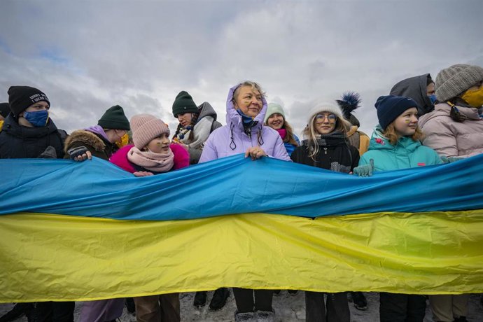 22 January 2022, Ukraine, Kyiv: People hold a long ukrainian flag in a nationalist march along the Paton bridge during the celebration of the Day of Unity. Photo: Celestino Arce Lavin/ZUMA Press Wire/dpa