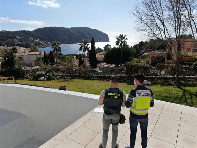 Un agente de la Guardia Civil y otro de la Policía Nacional en Mallorca, durante la 'Operación Casino', en la que se ha desarticulado una organización albanesa que traficaba con droga y blanqueaba el dinero desde Baleares.