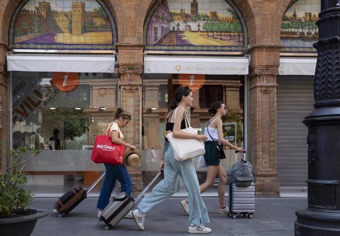 Archivo - Turistas con equipaje caminan por el centro de la ciudad en foto de archivo.
