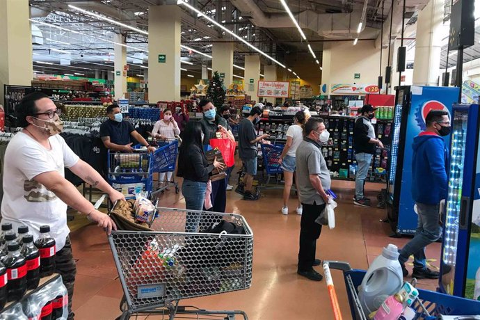 Archivo - Gente esperando la cola para pagar en Walmart