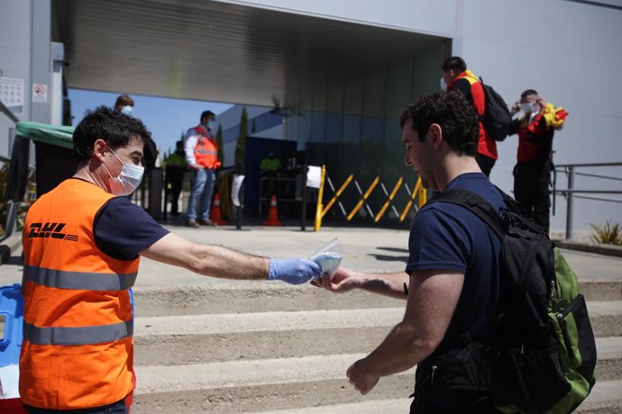 Archivo - Un trabajador de la planta de Mercedes-Benz de Vitoria recibe una mascarilla a su entrada a las instalaciones  En Vitoria (Álava), a 18 de mayo de 2020.