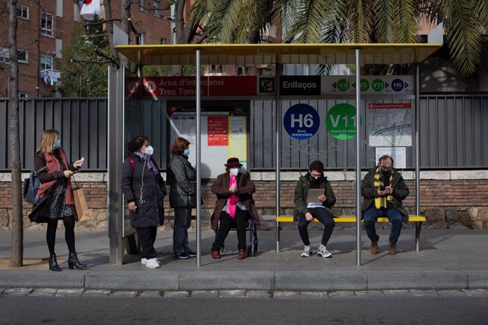Diverses persones esperen l'autobús en una parada durant la vaga 