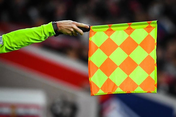 Archivo - Un asistente sostiene un banderín en un estadio.