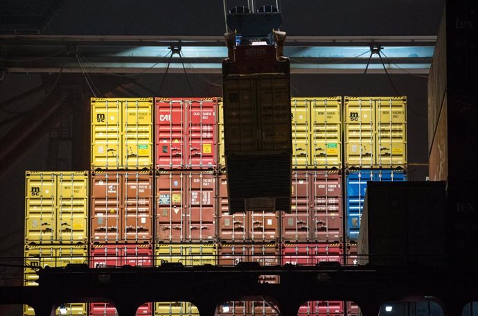 26 January 2022, Hamburg: A container ship lies at a terminal in the port and is being unloaded. Today, Federal Minister of Economics Habeck presents the Annual Economic Report 2021. Photo: Daniel Bockwoldt/dpa