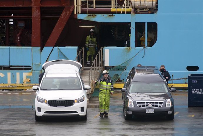 Personal portuario supervisa los coches fúnebres donde serán trasladados los cuerpos de los dos pescadores naufragados en Terranova que hoy han sido transportados en el buque Nexus que ha llegado al Puerto de San Juan de Terranova