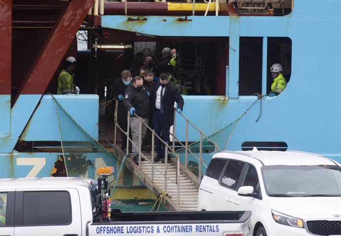 Personal forense transporta uno de los dos cuerpos de los pescadores naufragados en Terranova que hoy han sido transportados en el buque Nexus que ha llegado al Puerto de San Juan de Terranova, a 18 de febrero de 2022