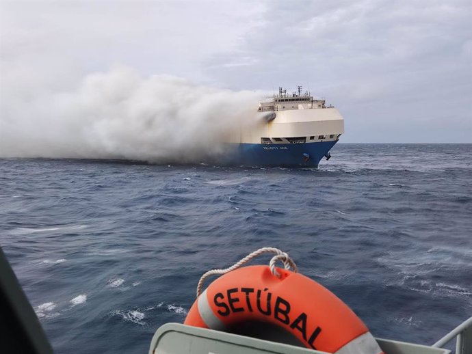 HANDOUT - 18 February 2022, Portugal, ----: Smoke rises from a freighter in the Atlantic Ocean south of the Azores. A freighter carrying about 4000 German cars belonging to the Volkswagen Group caught fire, according to the Portuguese Navy. The 22 crew 