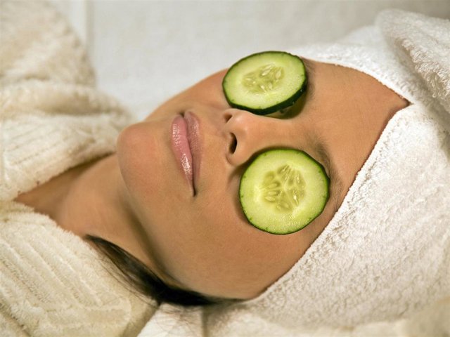 Woman recieving spa treatment with Cucumber.