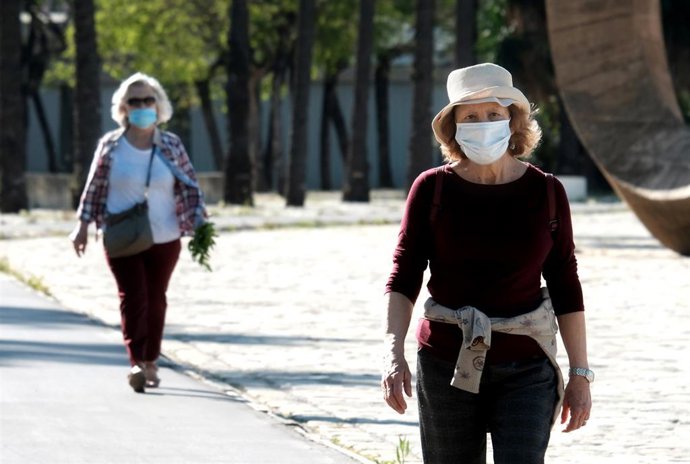 Archivo - Dos personas mayores protegidas con mascarillas pasean por el paseo Marqués de Contadero en Sevilla (Andalucía, España), a 02 de mayo de 2020.