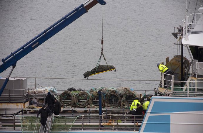 Una de las víctimas mortales del naufragio del buque gallego es bajado por los operarios del pesquero español 'Playa Menduiña Dos' a su llegada al Puerto de San Juan de Terranova, a 19 de febrero de 2022, en San Juan, Terranova (Canadá). Los barcos con 