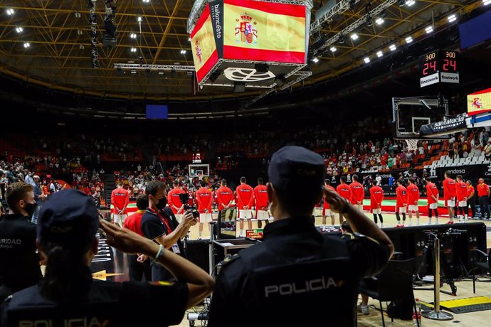 Archivo - Dos policías nacionales escuchando el himno de España antes de un partido de la selección española de baloncesto