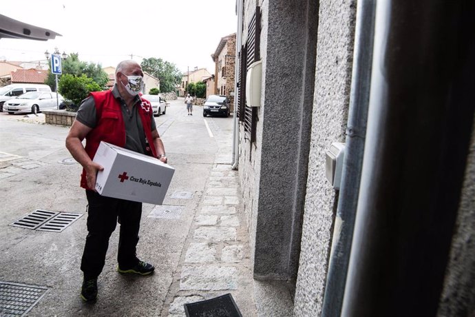 Archivo - Voluntarios de Cruz Roja entregan cestas de alimentación y productos de higiene a familias vulnerables en un pueblo de la sierra norte de Madrid.