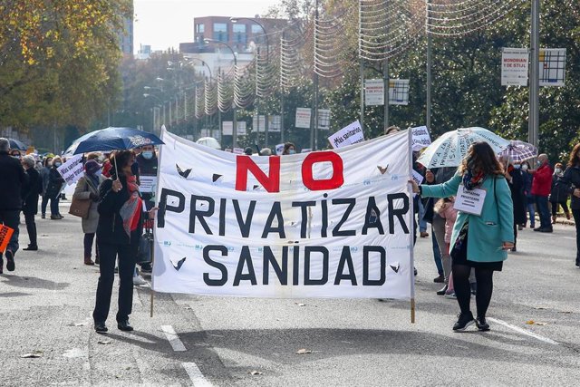 Archivo - Dos mujeres sostienen una pancarta donde se lee "No privatizar sanidad" durante una manifestación de la Marea Blanca en Madrid