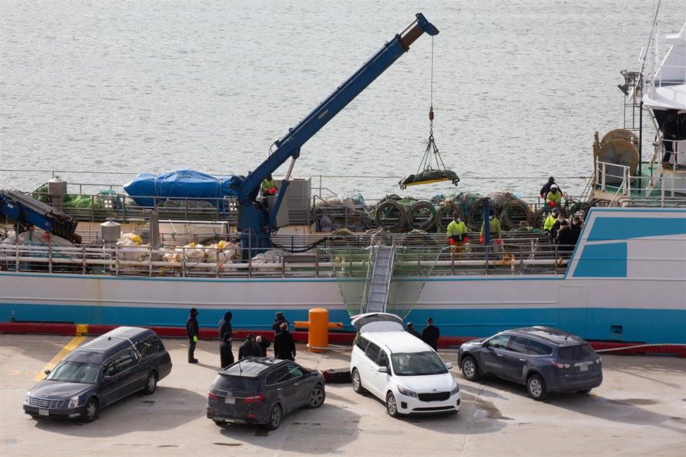 Operarios bajan con la ayuda de una grúa a uno de las personas fallecidas en el naufragio del buque gallego, a su llegada al Puerto de San Juan de Terranova, a 19 de febrero de 2022, en San Juan, Terranova (Canadá). 