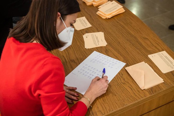 Una mujer recuenta los votos sobre la fusión de las localidades pacenses de Don Benito y Villanueva de la Serena, 