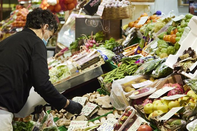 Archivo - El propietario de un puesto de frutas y verduras selecciona setas para un cliente en el Mercado de Triana, a 31 de diciembre de 2021 en Sevilla (Andalucía, España)