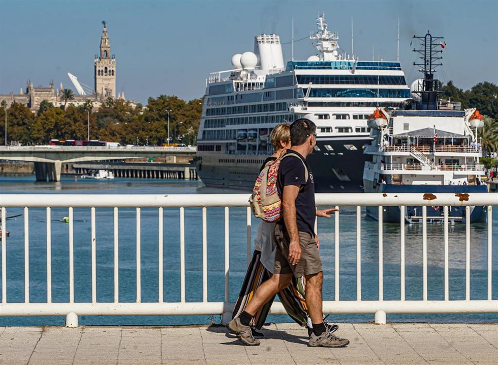 Archivo - Dos turistas  observan la entrada de los Cruceros 'Azamara Quest' y 'Hebridean Sky' a el Puerto de Sevilla 