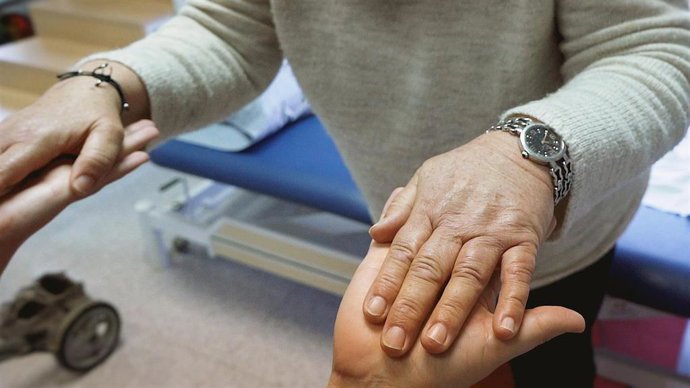 Las manos de un cuidador con una persona mayor.