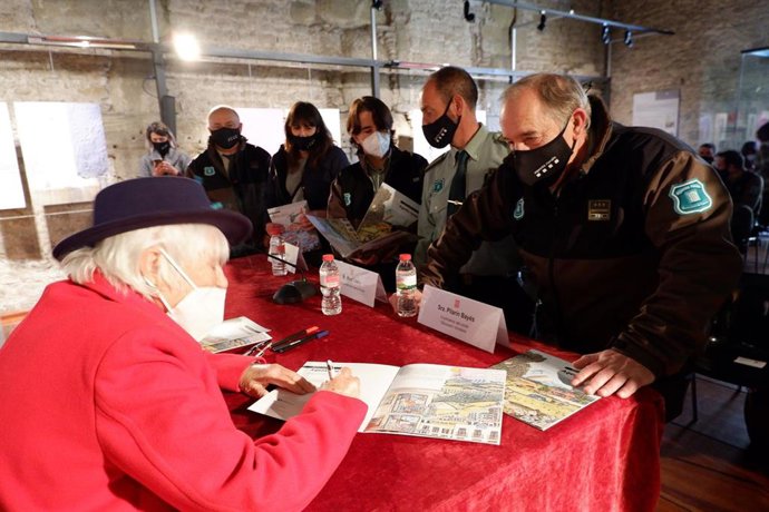 La ilustradora catalana Pilarín Bayés firma un ejemplar del libro 'Petita Histria dels Agents Rurals'