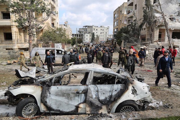Archivo - 18 February 2019, Syria, Idlib: Syrians inspect a damaged car after two bomb blasts have struck central Idlib. At least 13 people were killed and other 25 people were injured after two bomb blasts struck the north-western Syrian city of Idlib,