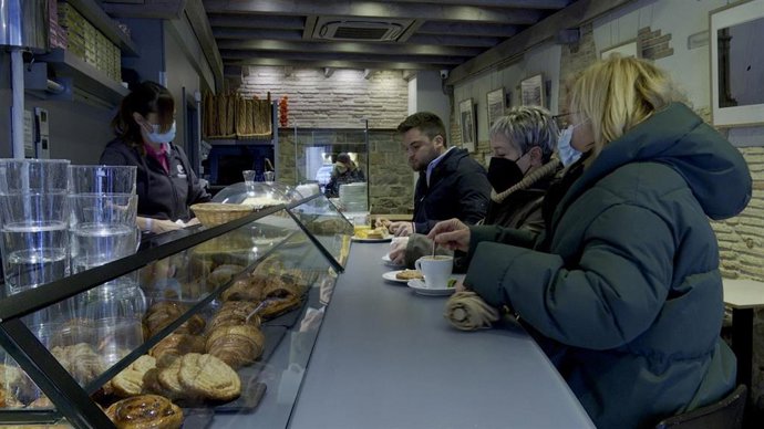 Varios clientes toman su consumición en la barra de un bar 