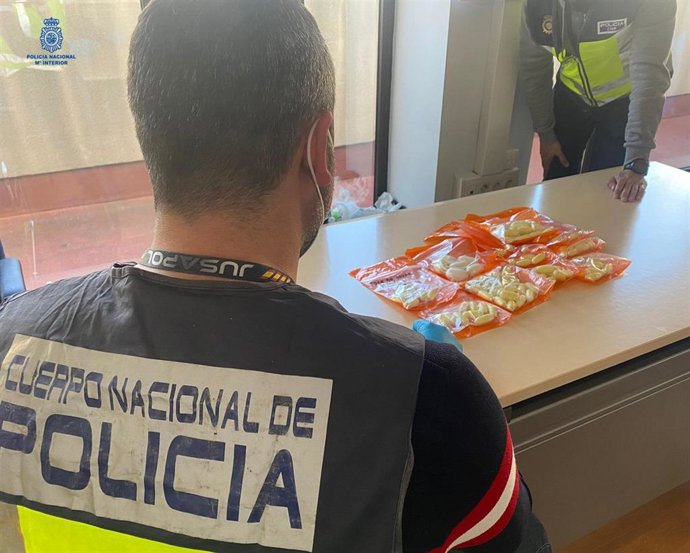 Un agente de la Policía Nacional, con los envoltorios de droga expulsados por un detenido en el aeropuerto de Palma.