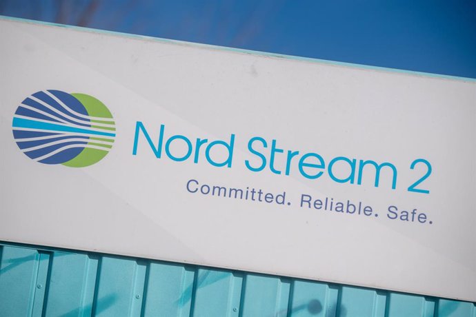 22 February 2022, Mecklenburg-Western Pomerania, Lubmin: A sign reading "Nord Stream 2 Committed. Reliable. Safe." hangs above a painted map on an information container for the Nord Stream 2 gas pipeline at the Lubmin industrial park. The German governm