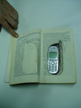 Teléfono móvil oculto en el interior de un libro.