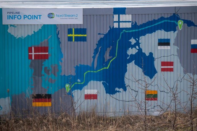 22 February 2022, Mecklenburg-Western Pomerania, Lubmin: A sign reading "Nord Stream 2 Committed. Reliable. Safe." hangs above a painted map on an information container for the Nord Stream 2 gas pipeline at the Lubmin industrial park. The German governm