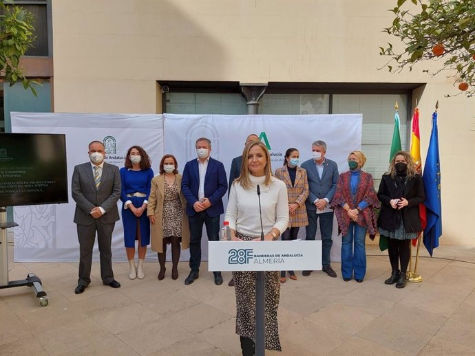 La delegada de la Junta en Almería, Maribel Sánchez Torregrosa, presenta los homenajeados con las banderas de Andalucía.
