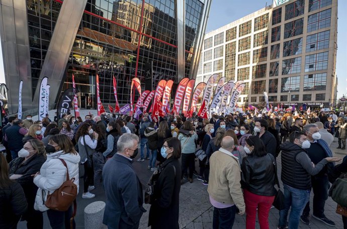 Un grupo de personas pertenecientes a los sindicatos CCOO, UGT y SECB llaman a las plantillas de CaixaBank a movilizarse frente a las Torres Kio, a 22 de febrero de 2022, en Madrid (España). 