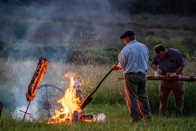 Así es que el asador comienza temprano a preparar la leña