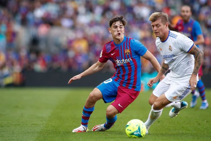 Archivo - Pablo Martín 'Gavi' conduce el balón ante Toni Kroos en el Clásico del Camp Nou de esta temporada