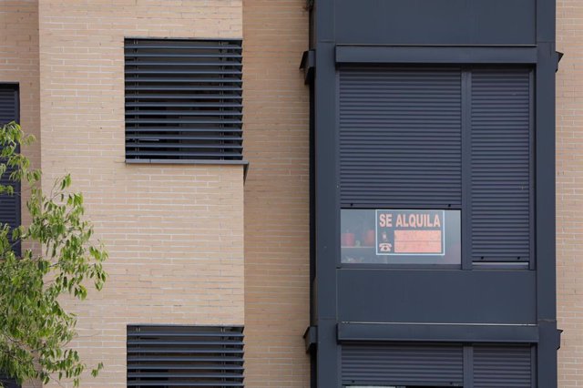 Archivo - En la fachada de un edificio se ve un cartel de 'Se Alquila' bajo la persiana de uno de los pisos, en una imagen de archivo.