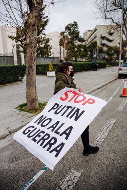 Una mujer sostiene una pancarta donde se puede leer "Stop Putin. No a la guerra" en una concentración ante la embajada rusa en Madrid tras los primeros ataques rusos registrados en Ucrania esta pasada madrugada 