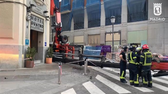 Bomberos del Ayuntamiento de Madrid trabajan tras la caída de una pluma de una grúa en la calle Sevilla.