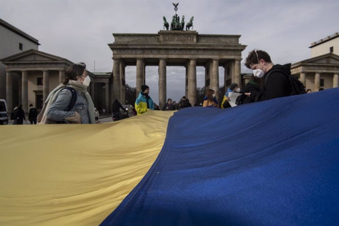 24 February 2022, Berlin: People take part in a protest in solidarity with Ukraine and against the Russian invasion, at Pariser Platz. Photo: Paul Zinken/dpa