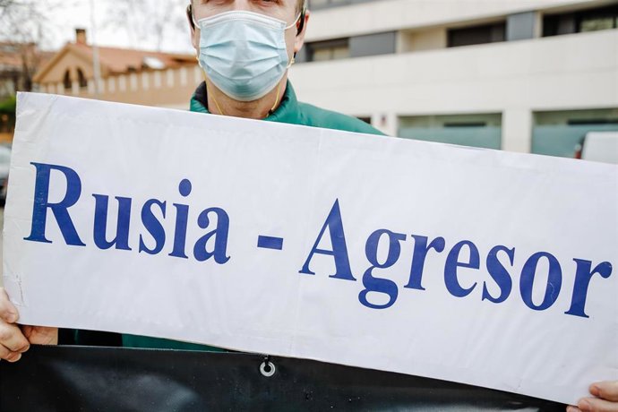 Un hombre sostiene una pancarta donde se puede leer "Rusia-Agresor" en una concentración ante la embajada rusa en Madrid tras los primeros ataques rusos registrados en Ucrania esta pasada madrugada 