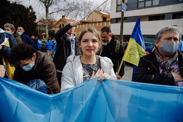 Una mujer canta el himno de Ucrania en una concentración ante la embajada rusa en Madrid
