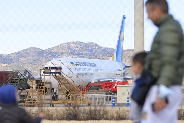 Tres personas observan uno de los cinco aviones ucranianos Boeign 737-800  que aterrizaron ayer en el aeropuerto de Castellón.
