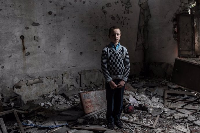 Archivo - Un niño en una escuela destruida por el conflicto en el este de Ucrania