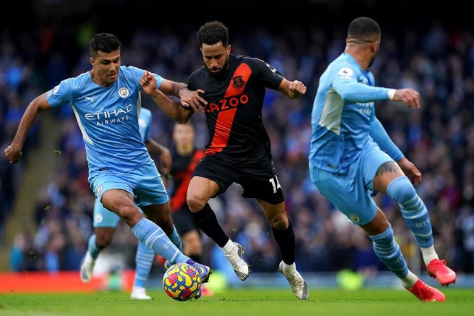 Archivo - El jugador del Everton Andros Townsend intenta driblar al futbolista español del Manchester City Rodri, en un partido de la Premier League 2021-2022 en el Etihad Stadium.